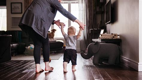 Bambino che impara a camminare con l'aiuto di un genitore e bretelle di sicurezza