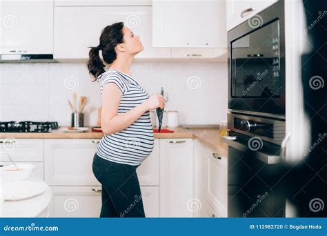 Donna incinta che cucina in cucina