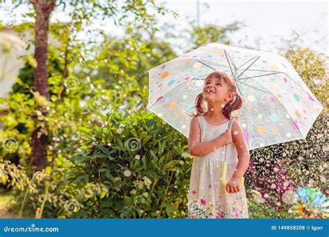 Illustrazione di una bambina sorridente con un ombrello colorato sotto la pioggia