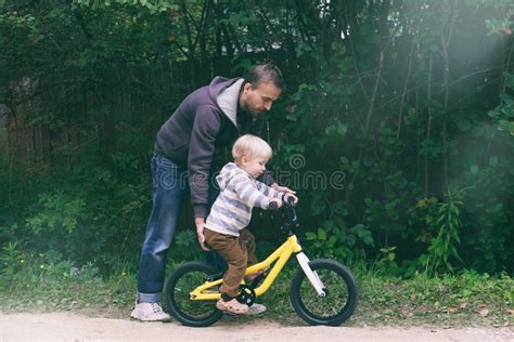 bambino che impara ad andare in bicicletta con l'aiuto di un genitore