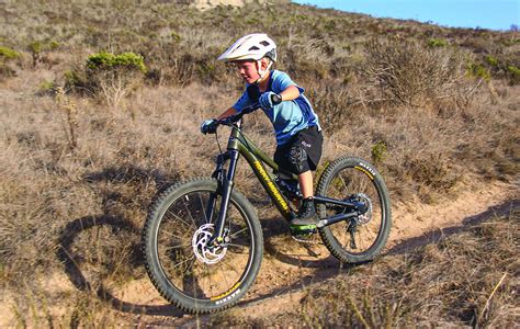 bambino che pedala su una mountain bike junior in un parco