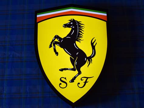 Dettaglio ravvicinato dello scudetto Ferrari 3D in TPU e della lavorazione traforata al laser sul tessuto