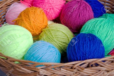gomitoli di lana colorati disposti su una cesta di vimini