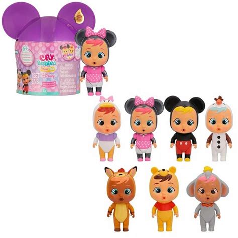 Dettaglio delle mini bambole Cry Babies con vari accessori sparsi su un piano di gioco