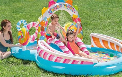 Bambino che gioca felice in una piscina per bambini con genitori sorridenti