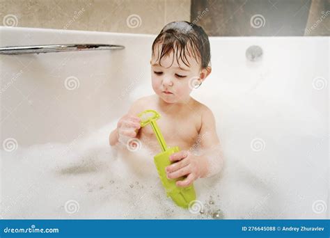 Bambino che gioca con giocattoli da bagno in una vaschetta
