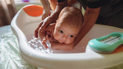 Bambino che fa il bagnetto in una vaschetta ergonomica con supporto