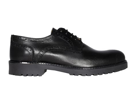 primo piano di scarpe inglesine da donna in camoscio su fondo neutro