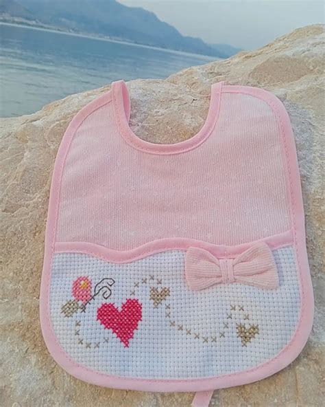 Palloncini colorati a punto croce su un bavaglino bianco