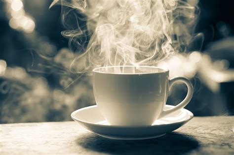 Tazza di caffè fumante su un tavolo di legno in un ambiente luminoso e naturale