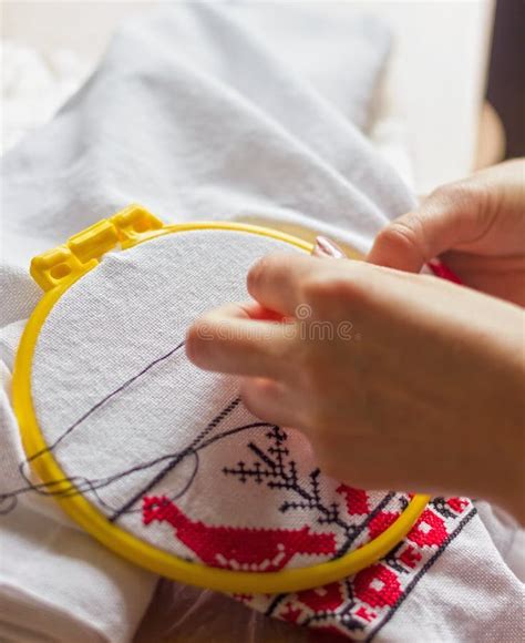 mani che ricamano a punto croce un dettaglio infantile