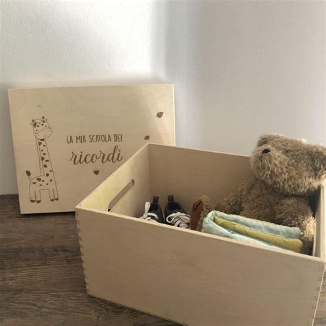Una scatola dei ricordi aperta contenente scarpine, braccialetti dell'ospedale e foto