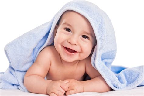 Bambino sorridente avvolto in un accappatoio con cappuccio dopo il bagnetto