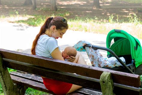 Una madre che allatta serenamente il proprio bambino in un parco pubblico