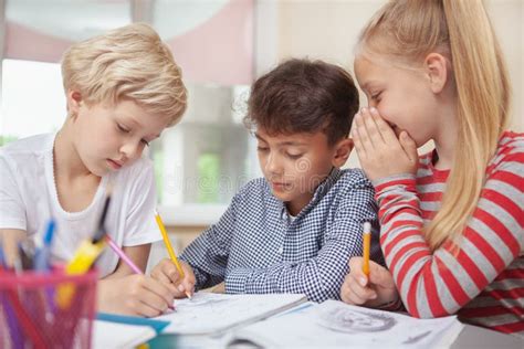 Bambini che disegnano emozioni su un tabellone