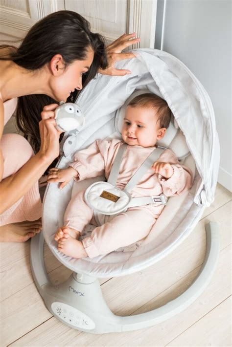 Bambino che riposa serenamente in una sdraietta con musica e dondolio