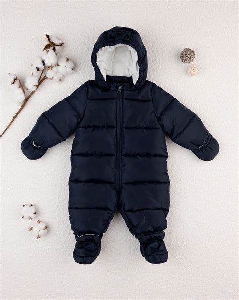 Bambino con piumino in tuta Prénatal sulla neve