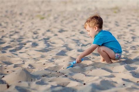 Bambino che gioca sulla sabbia in riva al mare durante una giornata soleggiata