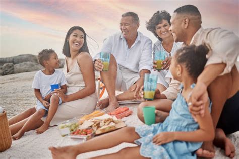 Famiglia che fa un picnic sulla spiaggia in una giornata limpida
