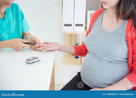Donna incinta che controlla la glicemia con un glucometro