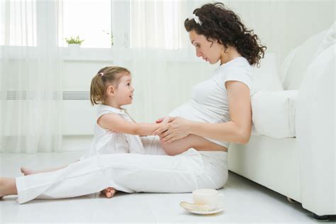 Bambino che accarezza dolcemente il pancione della mamma