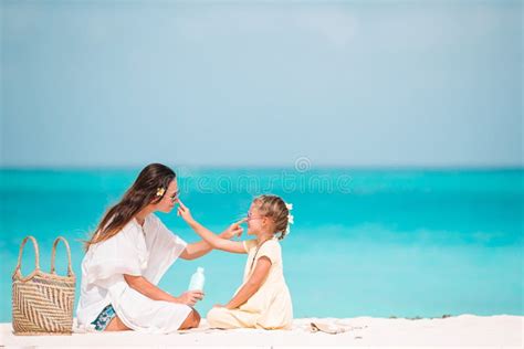 Famiglia che applica la crema solare sulla spiaggia
