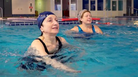 Donna incinta che esegue esercizi di galleggiamento in piscina