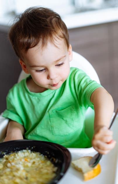 Bambino sorridente che esplora il cibo sul seggiolone