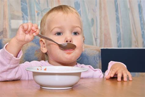 Bambino di 11 mesi che mangia con il cucchiaio