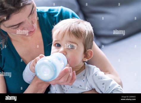 Bambino che beve dal biberon Chicco