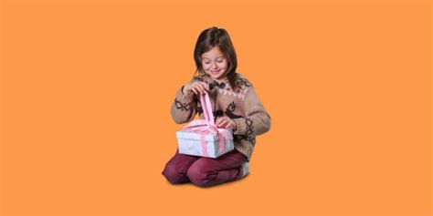 Bambina che scarta un regalo colorato con espressione felice