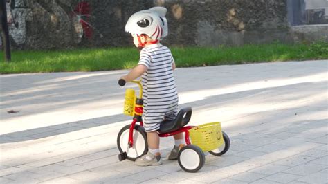 Bambino su triciclo in un parco