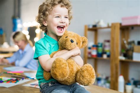 bambino che abbraccia un peluche o tiene in mano una copertina in un ambiente domestico rassicurante
