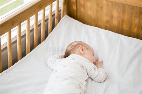 neonato che dorme in una culla moderna e luminosa