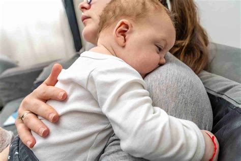 Bambino che fa il ruttino sulla spalla dell'adulto