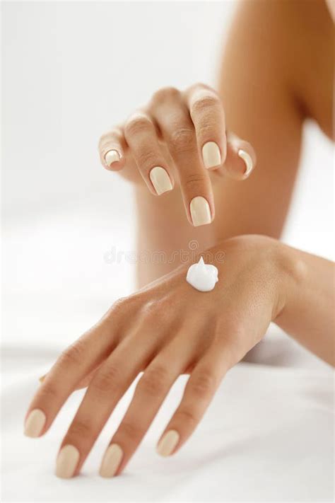 Dettaglio delle mani che applicano la crema su una coscia