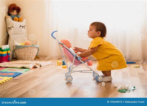 Bambina che gioca con passeggino Barbie interattivo