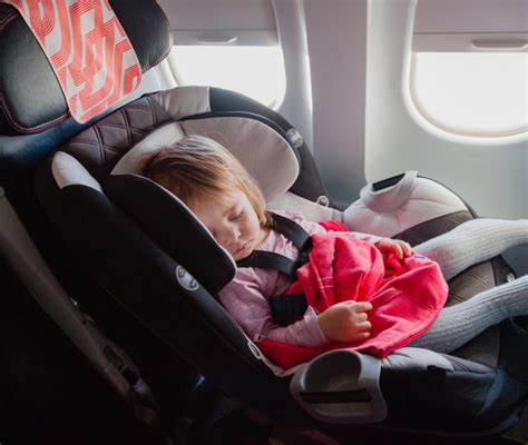 Bambino che dorme sereno in un seggiolino auto in aereo