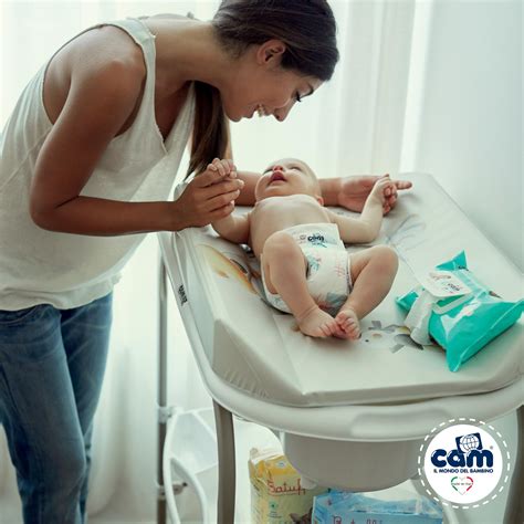 bambino di circa 1 anno che viene cambiato su un fasciatoio portatile