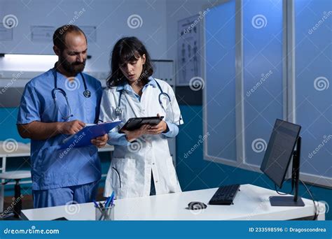 Un team di specialisti medici che analizza dati su un monitor in un ambiente di lavoro collaborativo