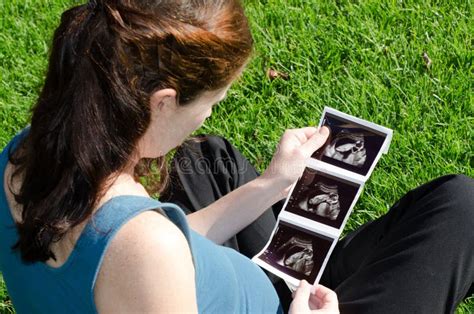 Donna incinta che guarda con curiosità un'ecografia