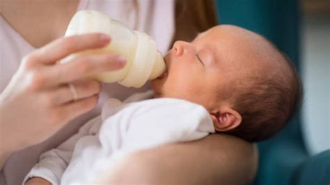 Mamma che prepara un biberon con un dosatore