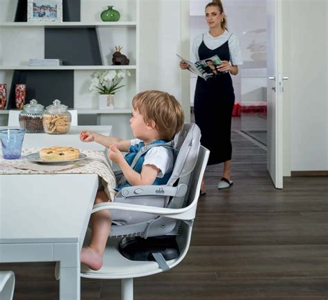 Genitori che danno la pappa a due gemelli in rialzi da sedia