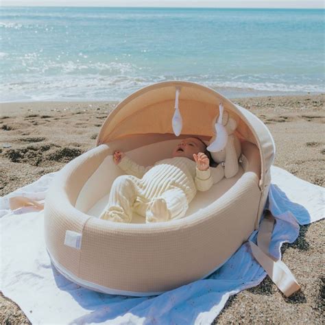famiglia con bambino in culla portatile al mare