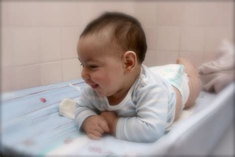 Bambino sorridente sul fasciatoio con mamma