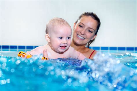 Parents and baby in pool during baby swimming class
