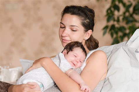 Neonato che dorme serenamente tra le braccia della madre