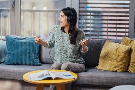 Donna in dolce attesa che ascolta musica rilassante con le mani sul pancione