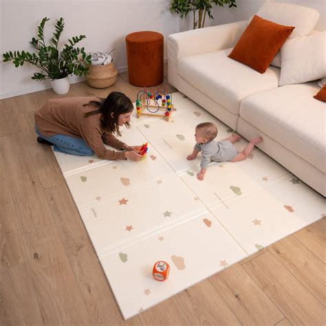 Neonato in posizione tummy time sul tappeto gioco