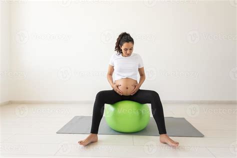 Donna incinta seduta correttamente su una fitball